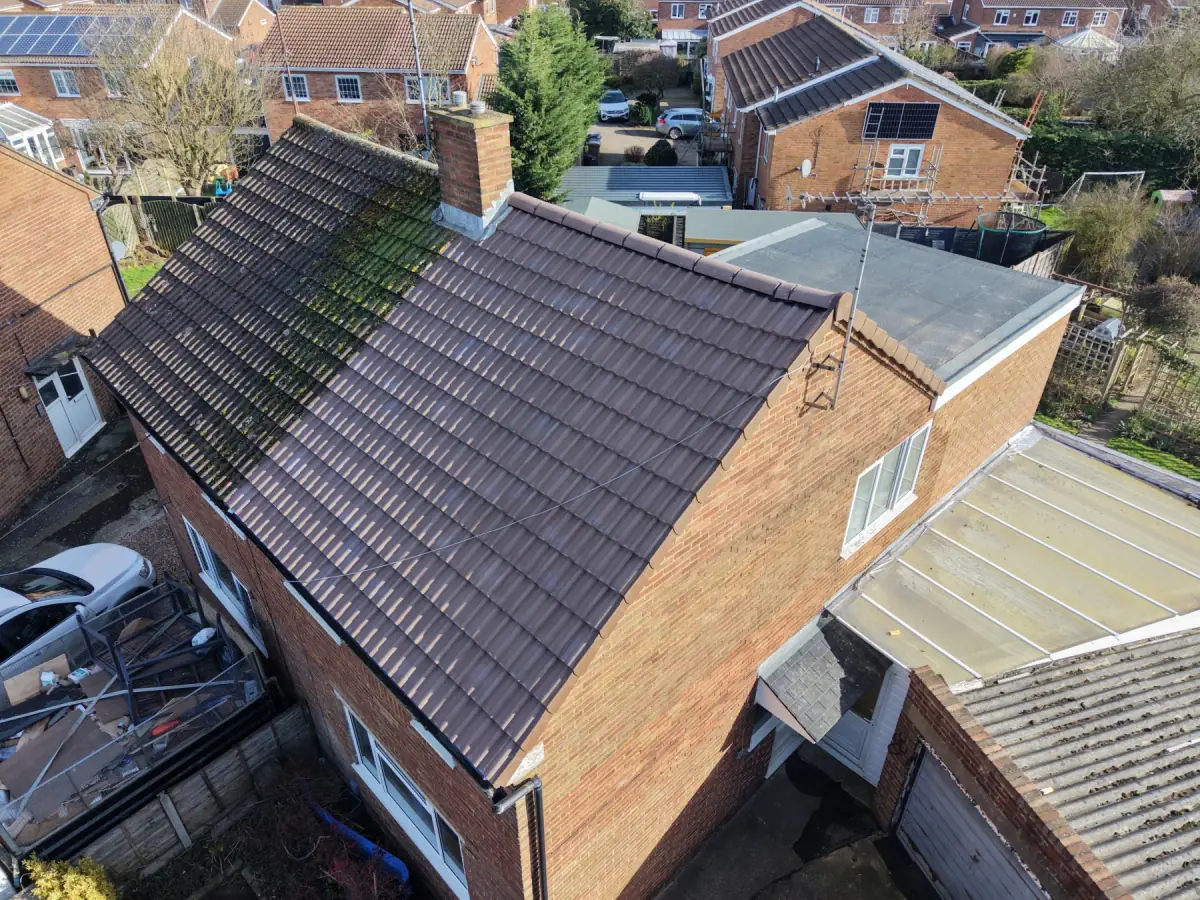 Aerial view of a detached brick house with a newly tiled roof, completed by Expert Roofing Services